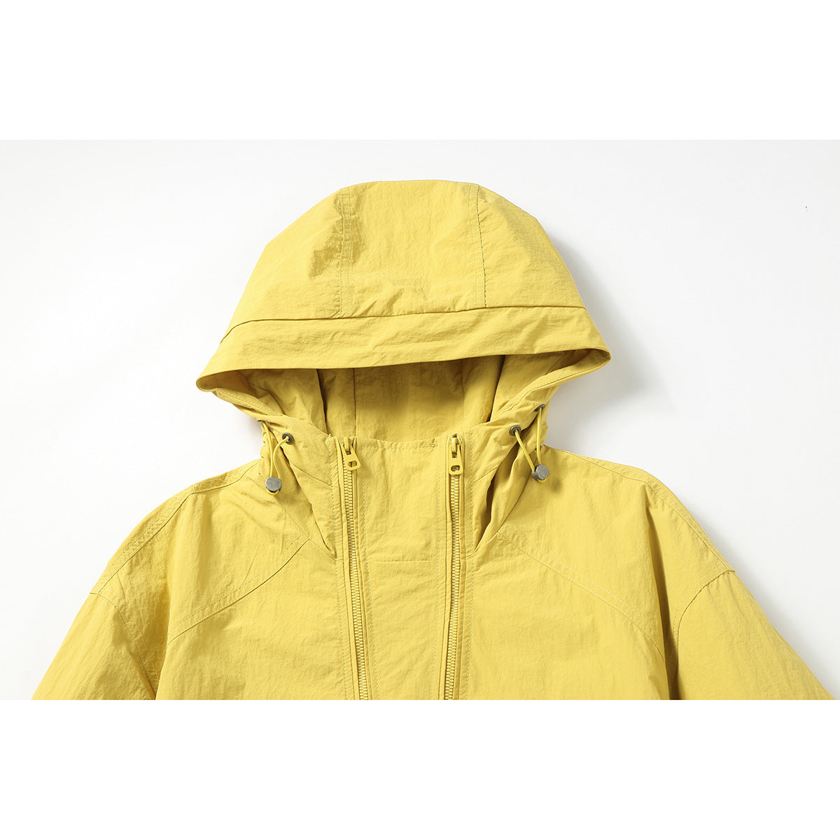 Close-up of a yellow hooded jacket showing the hood, drawcords, and double front zippers.