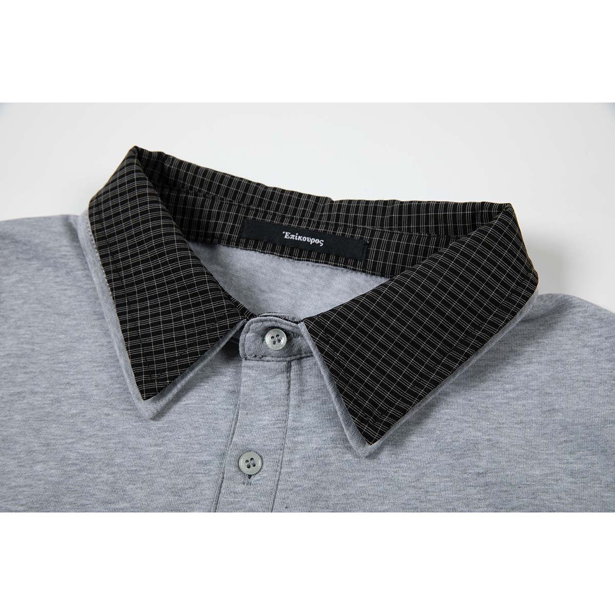 Close-up of a heather-gray polo shirt with a black fine-check collar and two-button placket.