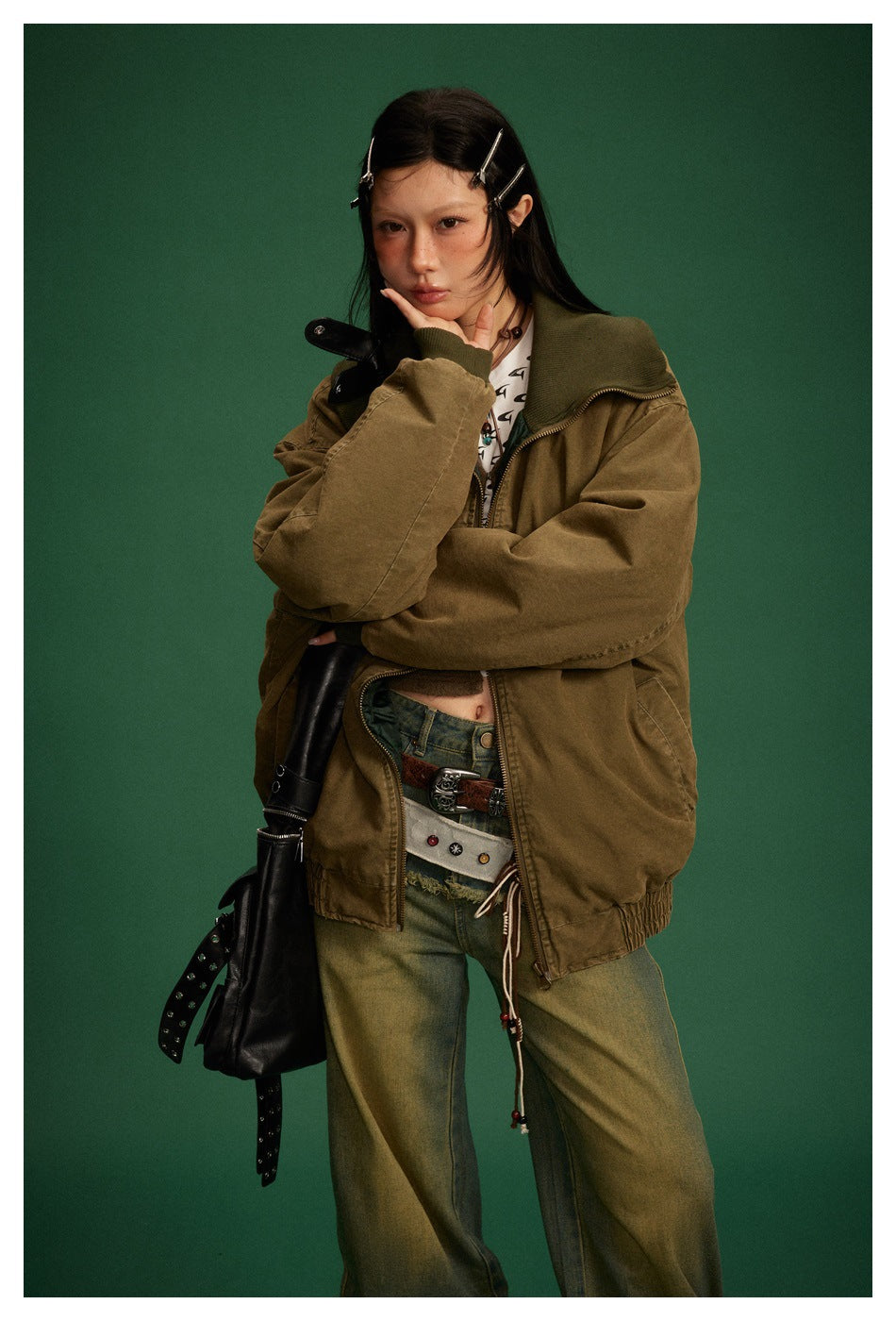 Model wears an olive-brown oversized zip jacket with a dark green ribbed collar and gathered elastic hem.