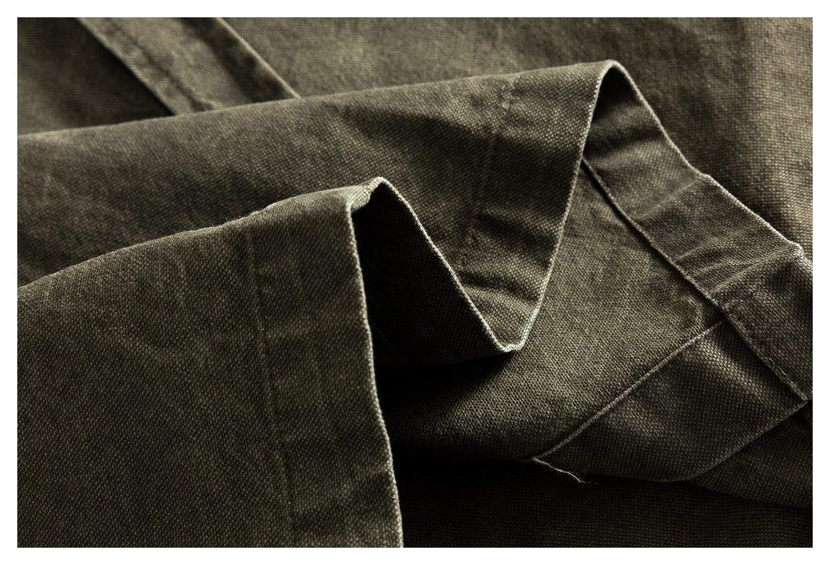 Close-up of folded olive-gray shirt fabric with a stitched edge and seam.