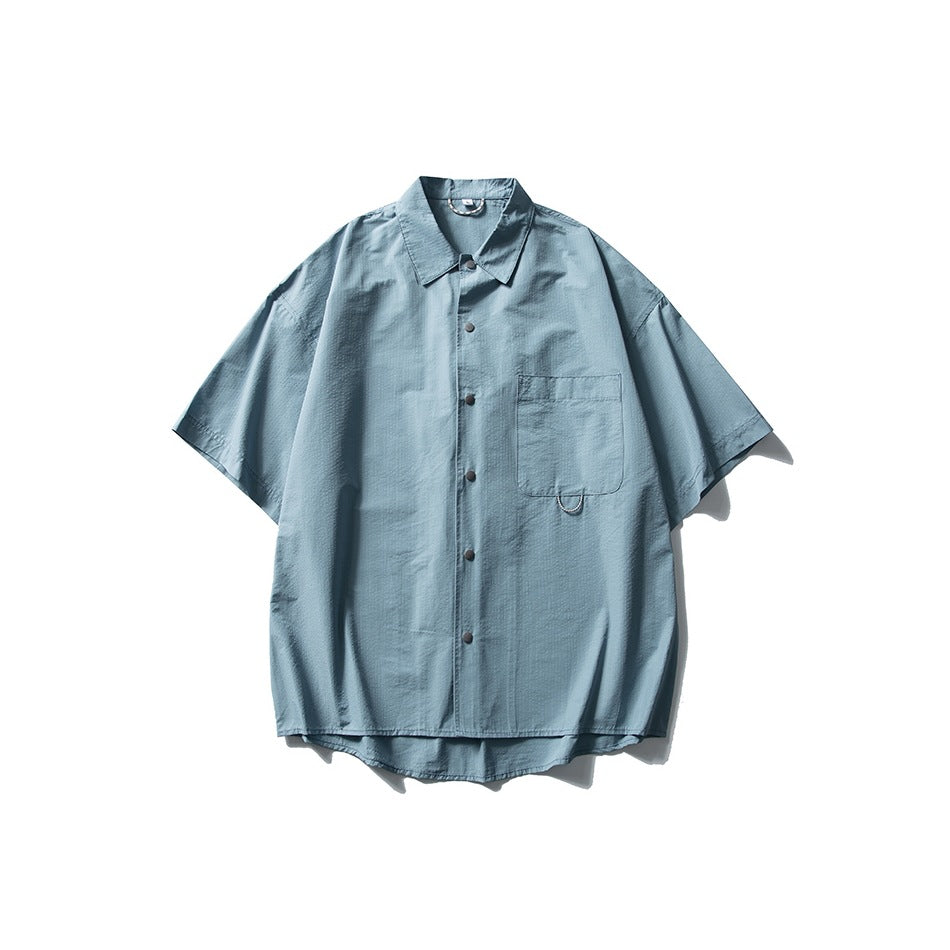 Blue short-sleeve button-front shirt with collar and chest pocket, flat lay on white background