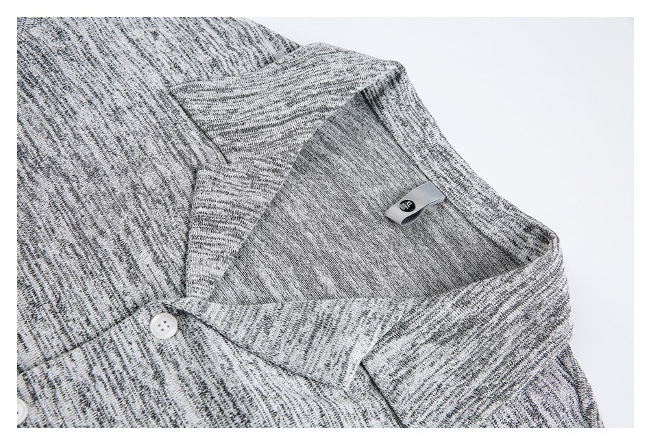 Close-up of the shirt collar, inner label, and white button on light heather-gray fabric.