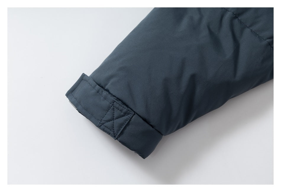 Close-up of a dark navy jacket sleeve with an adjustable cuff tab.
