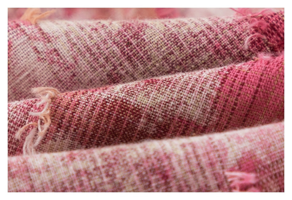 Macro view of pink, cream, and brown woven checks with loose frayed threads.