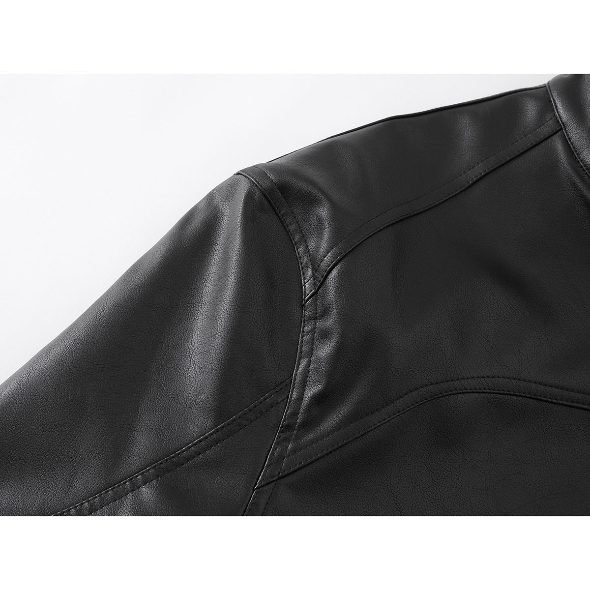Close-up of the black jacket’s shoulder seam and curved stitched panels.