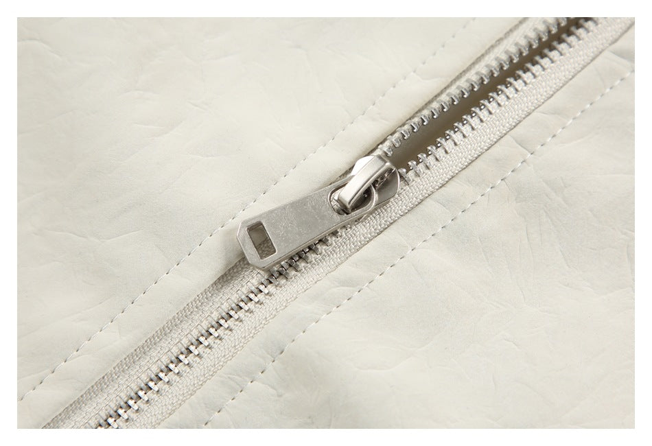 Close-up of the ivory jacket's diagonal front zipper with a silver metal pull.