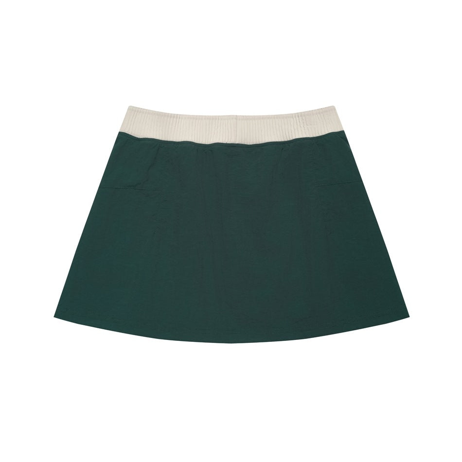 Back view of a dark green flared skirt with a wide ivory ribbed waistband.