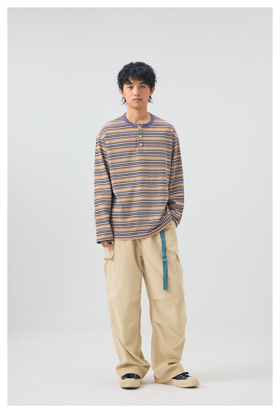 Model wearing the purple striped long-sleeve button-neck top with beige cargo pants, front view