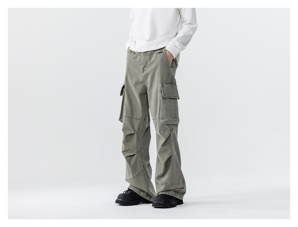 Model wearing gray-green wide-leg cargo pants with oversized flap pockets, shown from a three-quarter front angle.