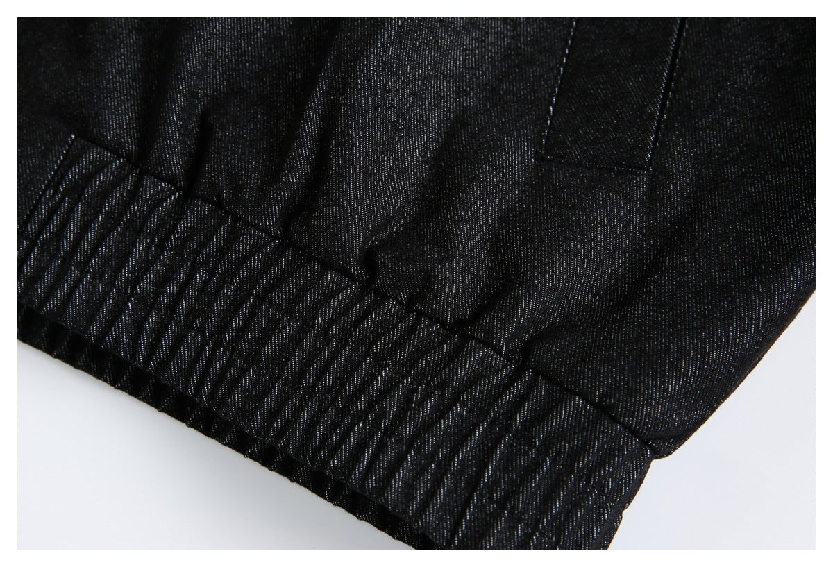 Close-up of black garment fabric with gathered stitching along an edge.