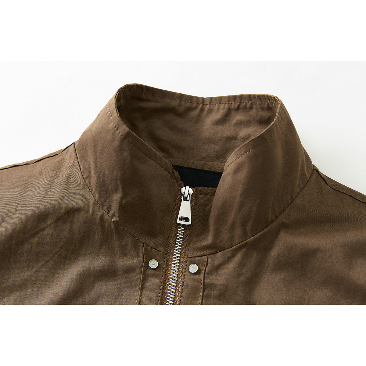 Close-up of a brown jacket's stand collar and silver front zipper.