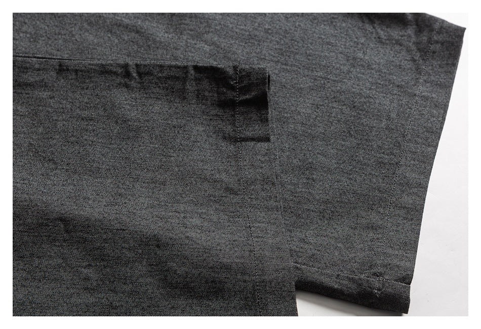 Close-up of charcoal trouser fabric with a seam and folded hem.