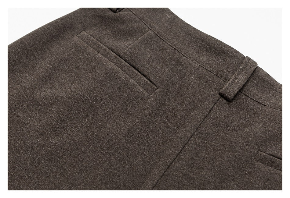 Close-up of dark brown trousers showing a rear welt pocket and waistband belt loop.