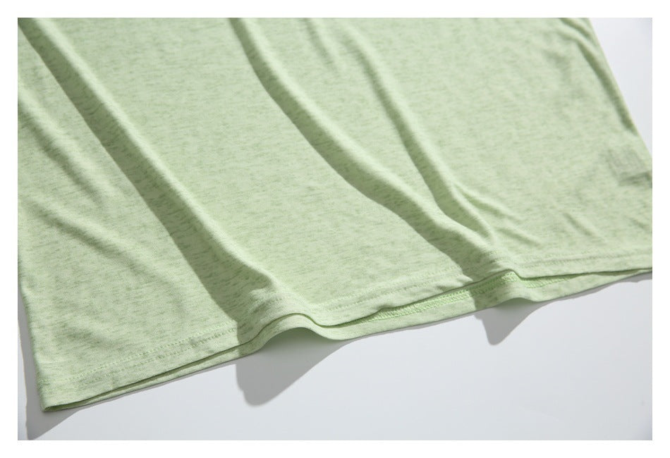 Close-up of the pale green shirt's stitched bottom hem.