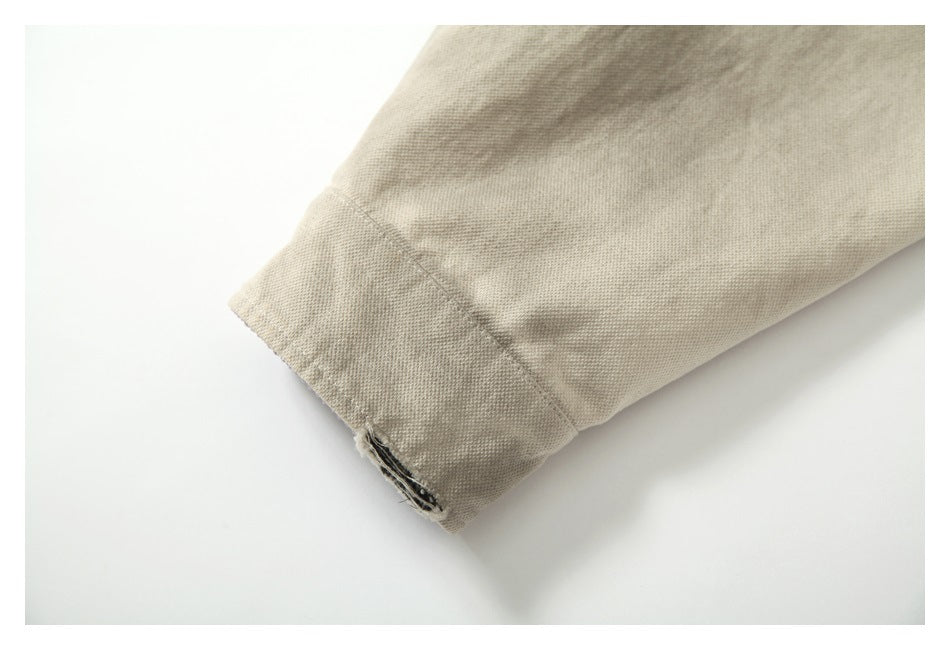 Close-up of a beige jacket sleeve cuff with visible seam stitching.