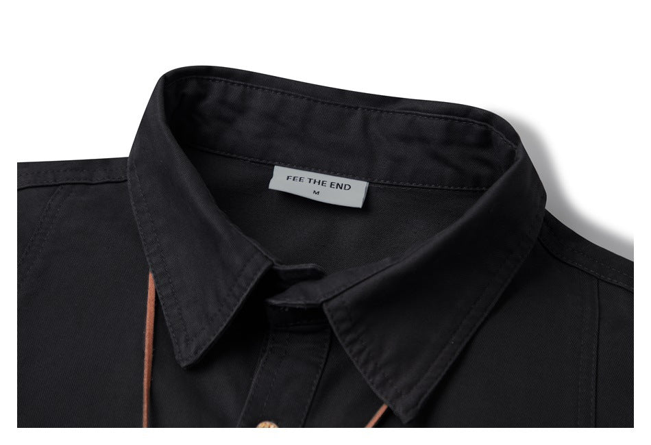 Close-up of a black shirt's pointed collar and sewn-in neck label.