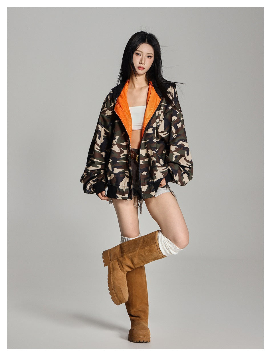 Model wearing open camouflage hooded jacket with orange lining over a white top, shorts and tan suede boots