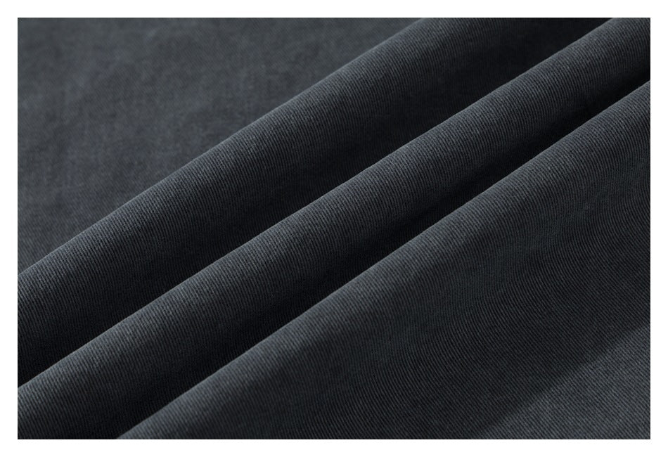 Close-up of dark charcoal fabric draped in soft folds, showing a fine surface texture.