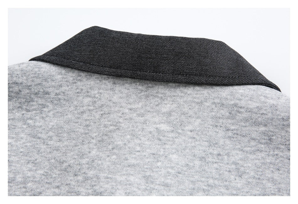 Close-up of a dark charcoal collar against light gray heather garment fabric.