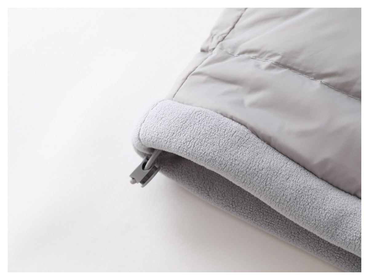 Close-up of a light gray jacket edge with plush lining and a small plastic toggle.