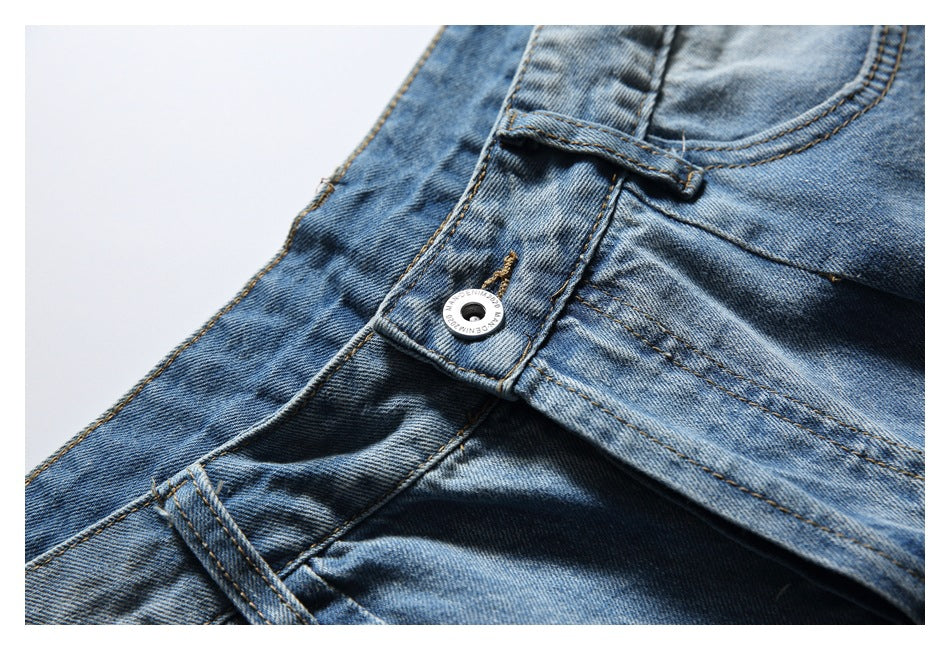 Close-up of the light blue denim shorts waistband, belt loop, front pocket, and metal button.