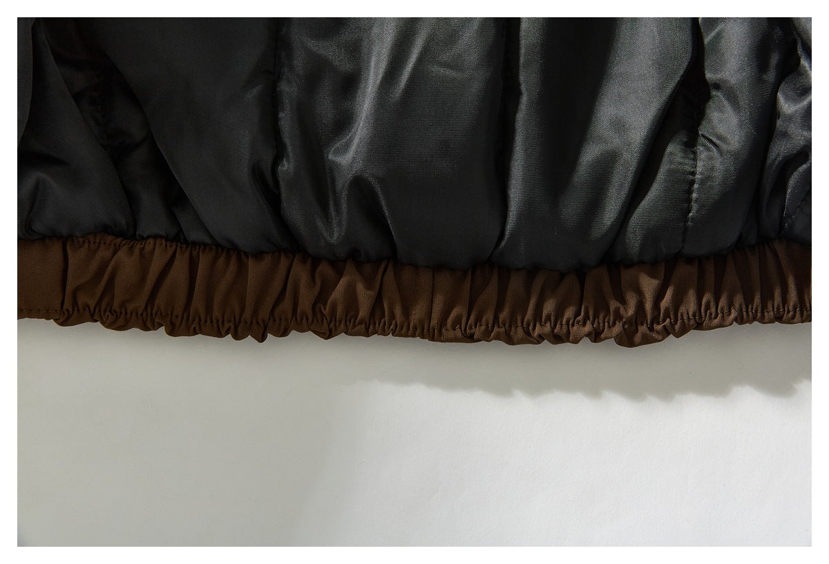 Close-up of the jacket's gathered brown elastic hem beside the black interior lining.