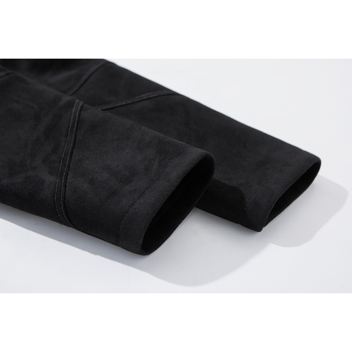 Close-up of the black jacket's sleeve cuffs and stitched panel seams.
