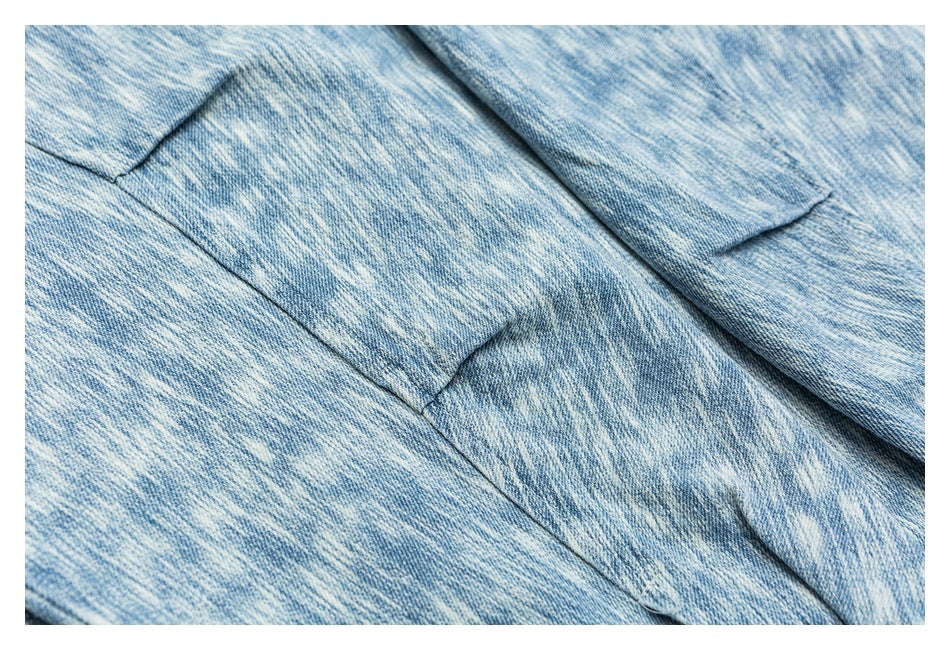 Close-up of overlapping light blue denim panels with visible seams and stitching.