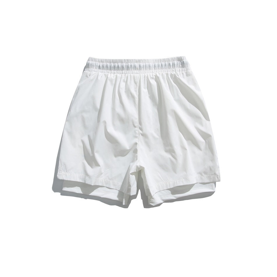 White shorts flat lay, back view, with elastic waistband and visible inner layer beneath the outer hem