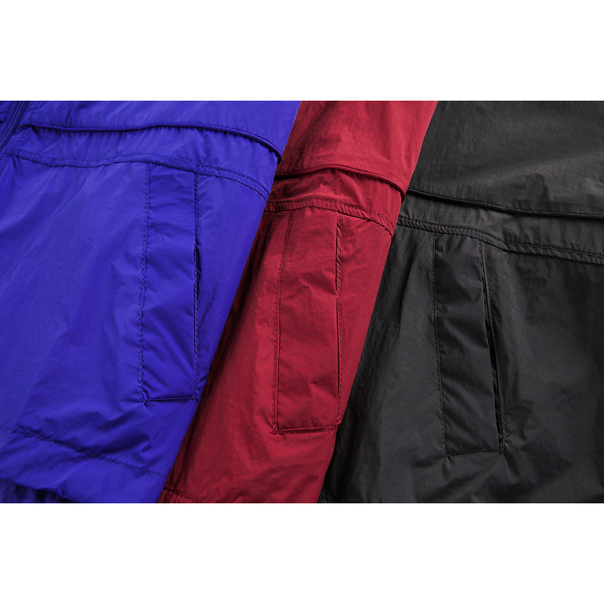 Close-up of blue, red, and black jacket fronts showing stitched pocket details.