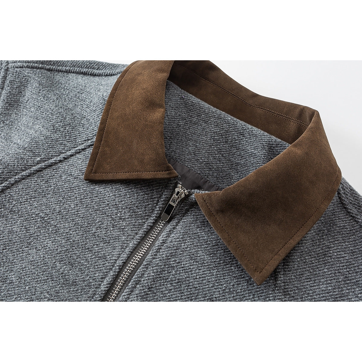 Close-up of a gray textured jacket with a contrasting brown collar and metal front zipper.