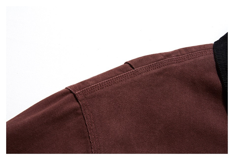Close-up of the burgundy jacket's shoulder seam and stitching beside the black collar.