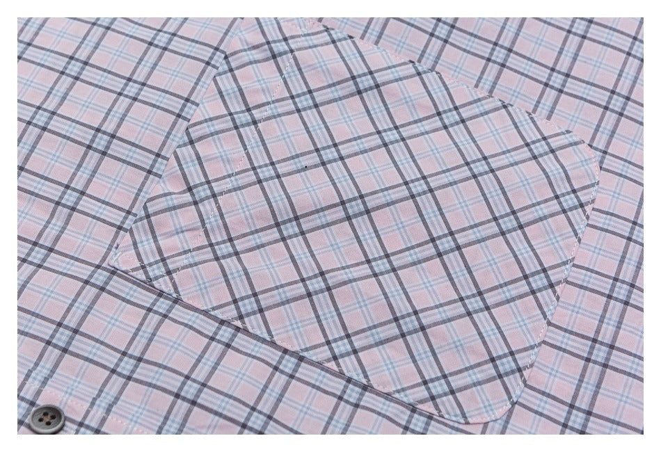 Close-up of a rounded chest pocket on a pale pink plaid shirt.