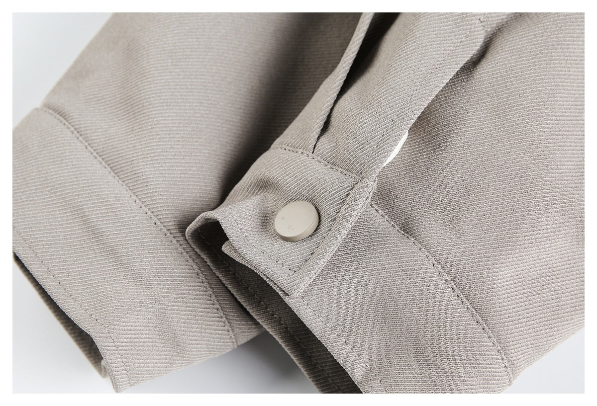 Close-up of a light taupe sleeve cuff with a round button fastening.