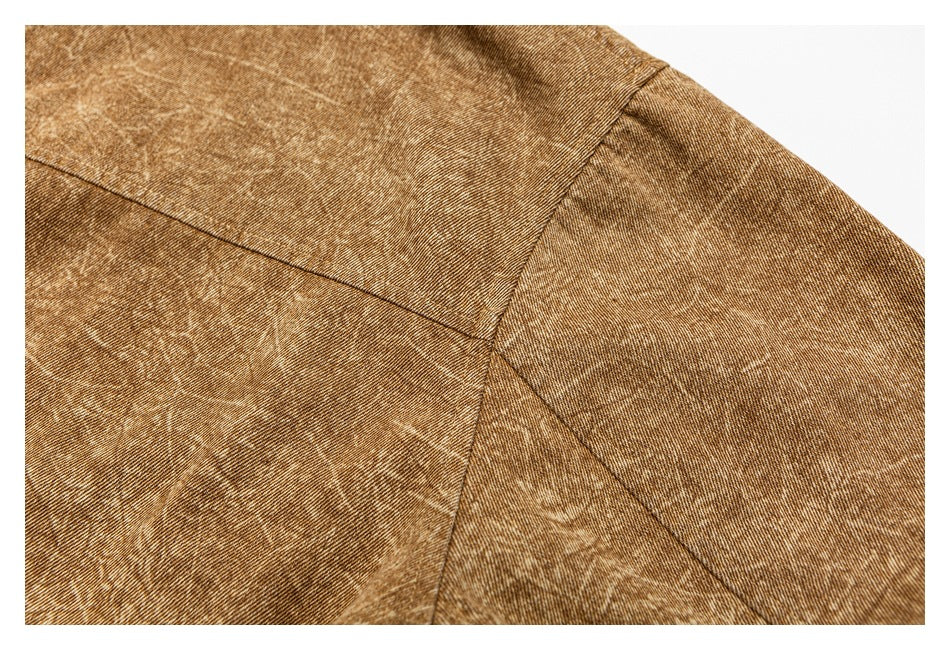Close-up of brown mottled fabric showing curved and diagonal stitched seams.