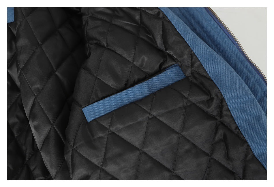 Close-up of the black quilted jacket lining with a blue-trimmed interior pocket and zipper edge.