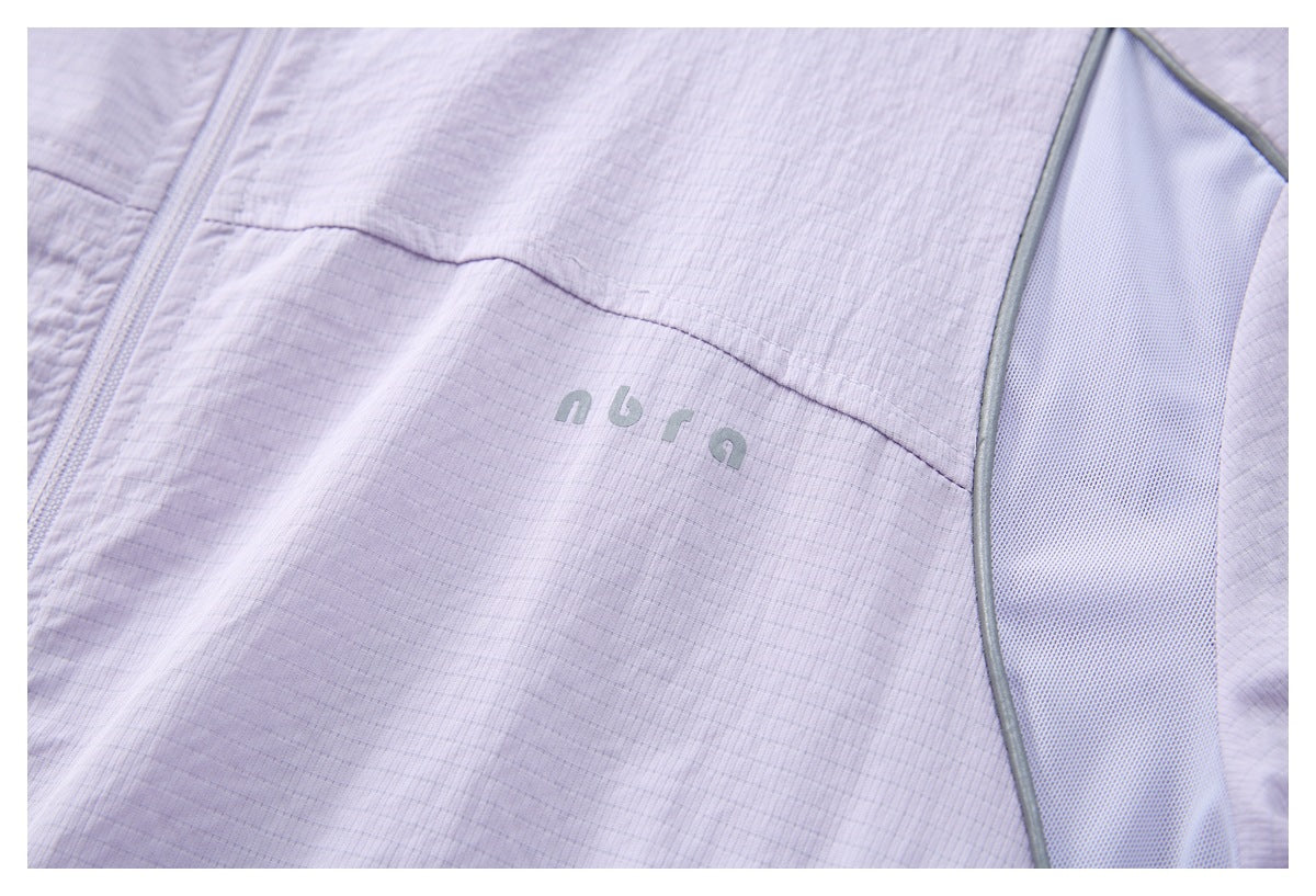 Close-up of a small gray logo and mesh side panel on a pale lavender jacket.