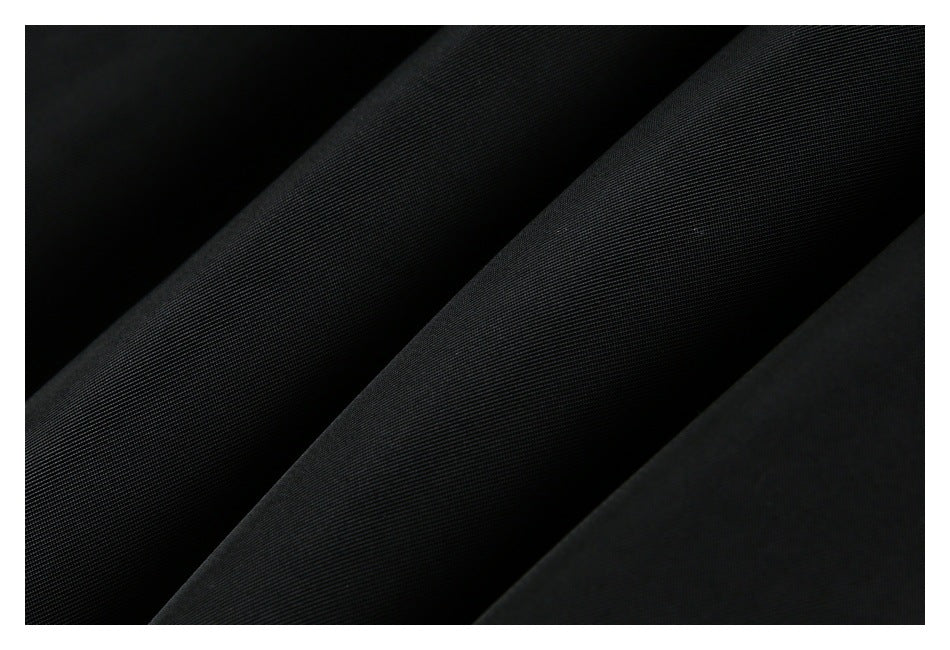 Macro view of black fabric arranged in diagonal folds, showing its fine texture.