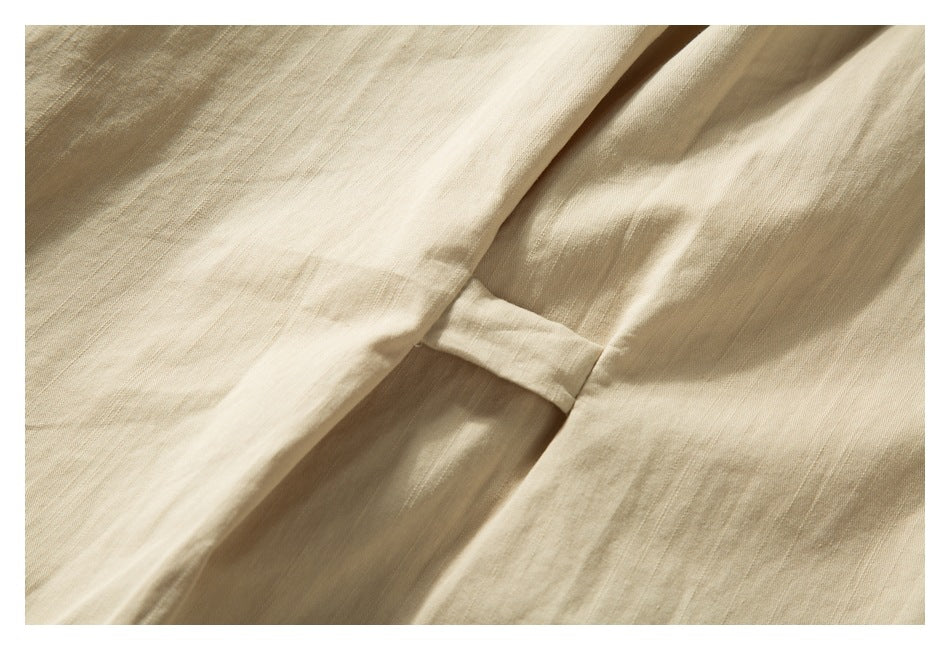 Close-up of beige fabric with a narrow stitched seam and soft folds.