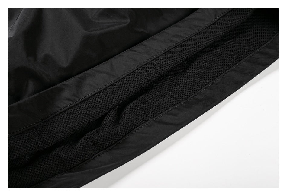 Close-up of black pants showing a textured mesh panel beside a stitched fabric edge.