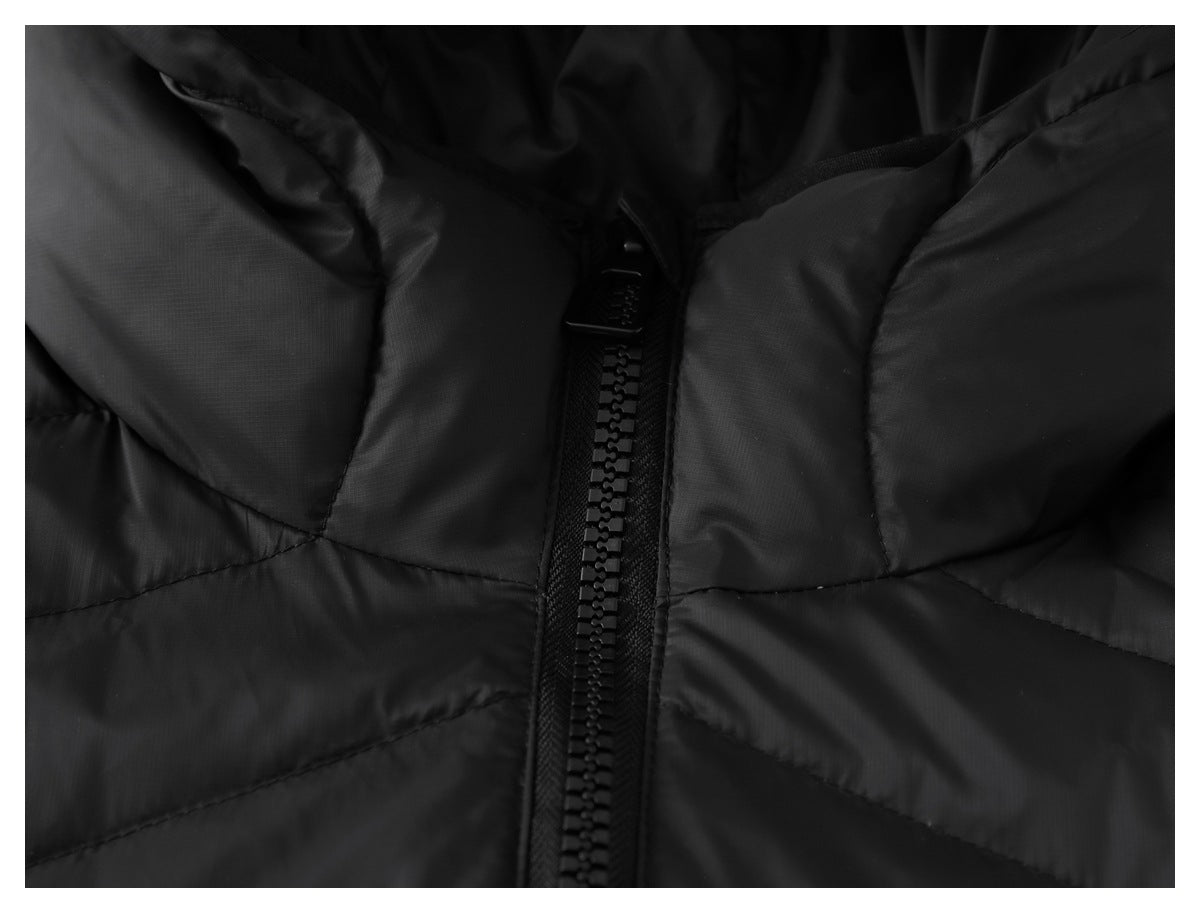 Close-up of a black quilted puffer jacket's front zipper and angled stitched panels.