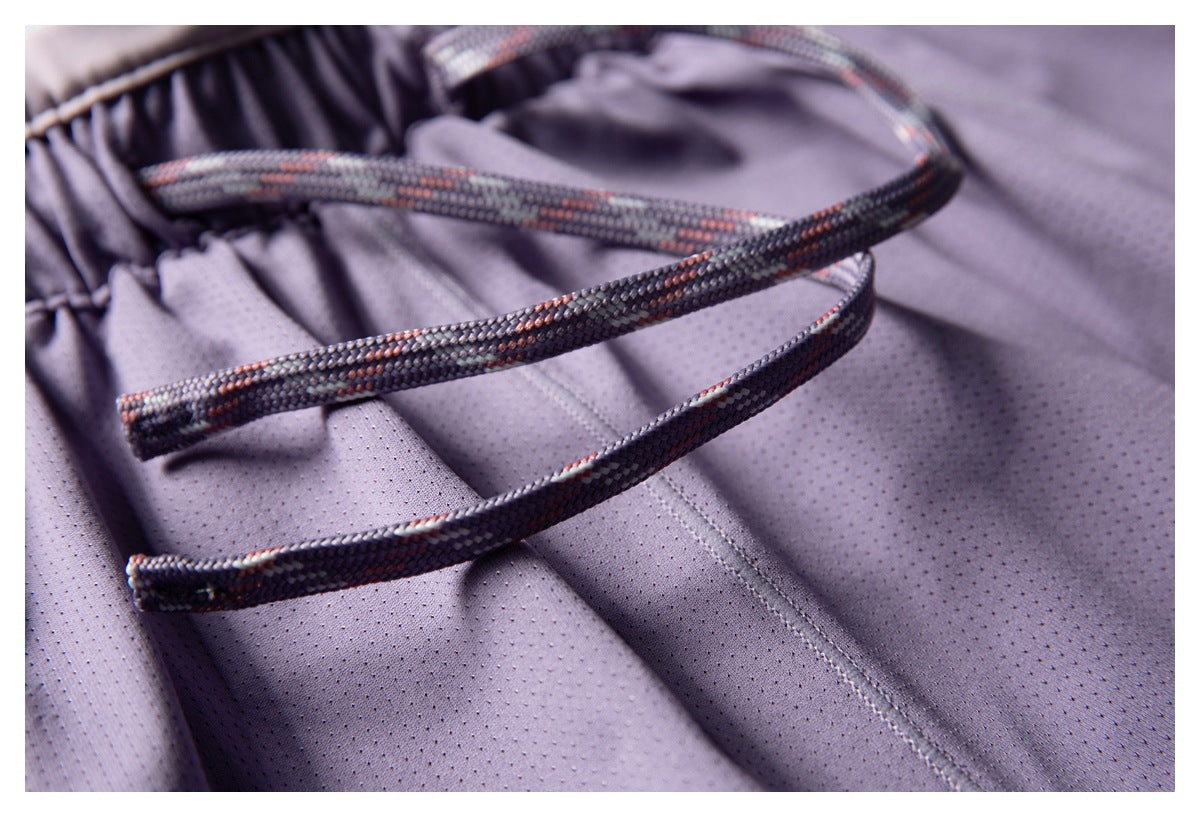 Close-up of the patterned drawstrings and elastic waistband on lavender perforated shorts.