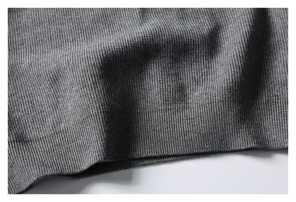 Close-up of the ribbed lower hem of a gray knit garment.