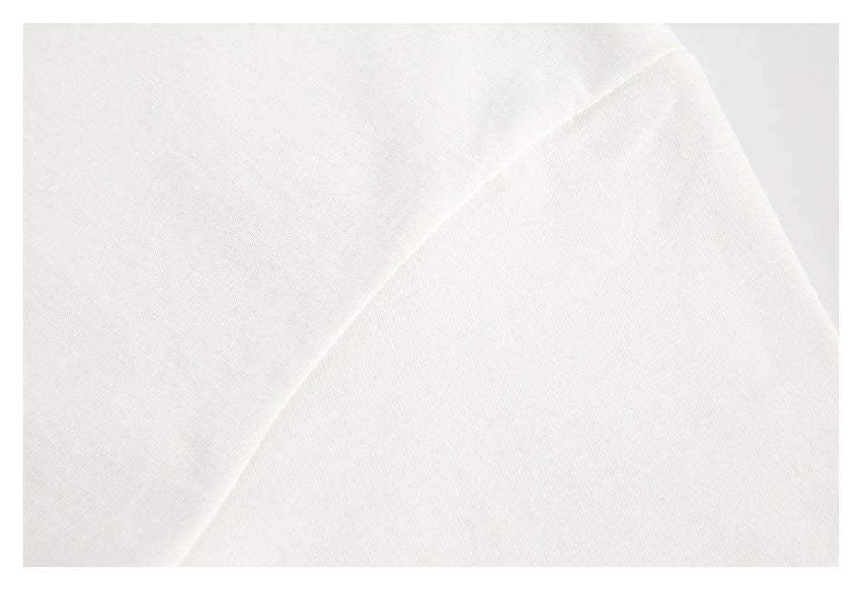 Close-up of a curved seam joining two sections of white garment fabric.