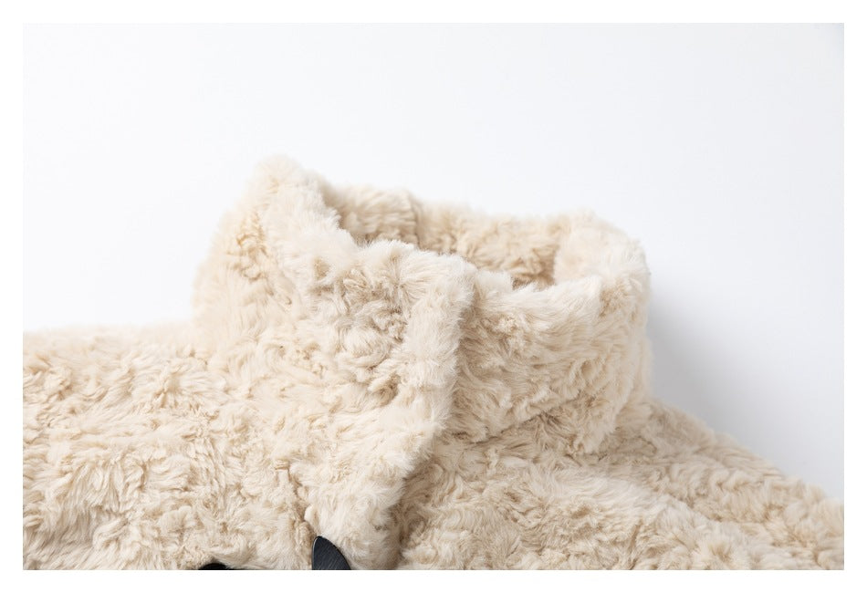 Close-up of the ivory plush coat's raised collar and overlapping front neckline.