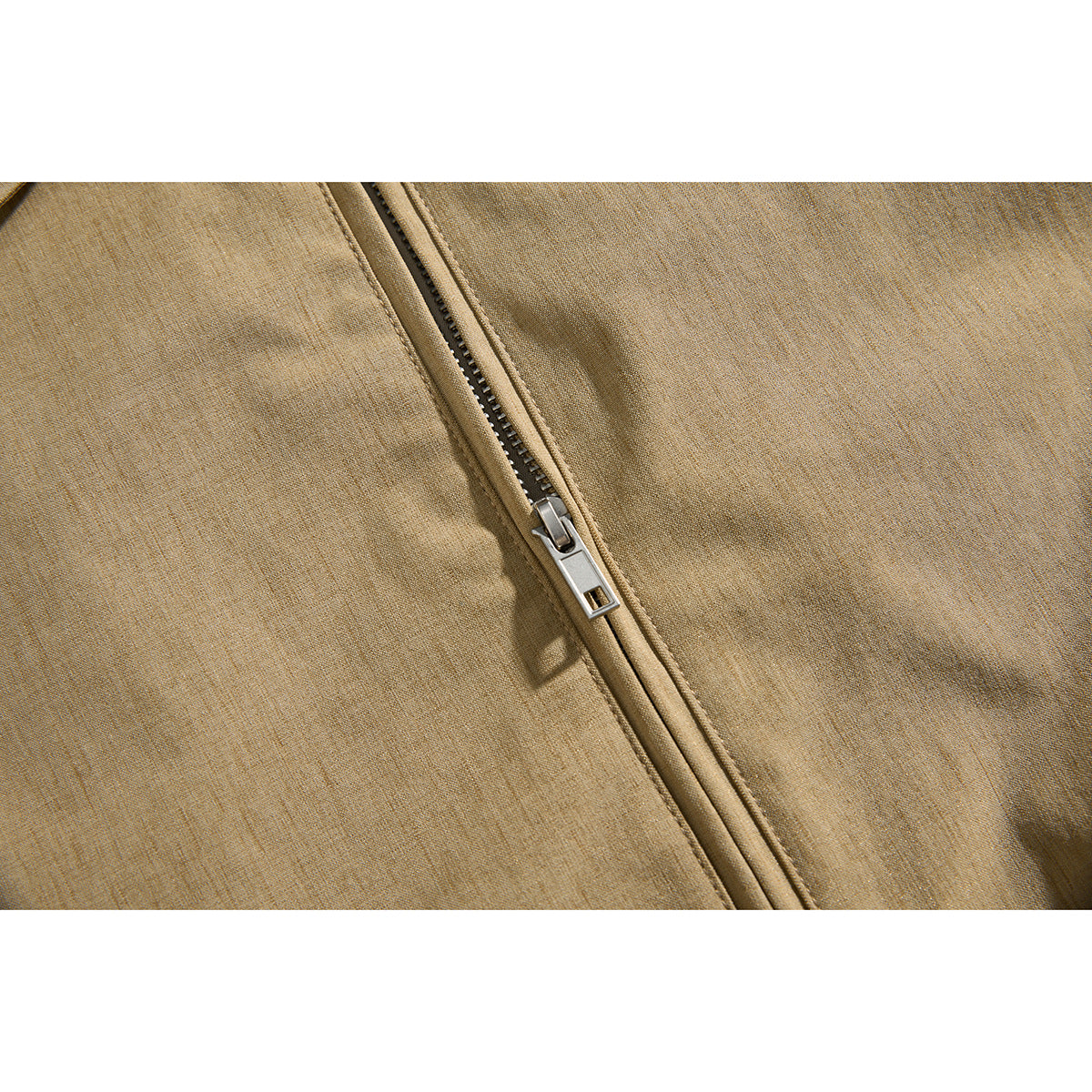 Close-up of the metal zipper on a tan jacket.