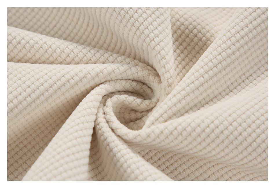Cream waffle-textured fabric gathered into folds, showing its raised surface.