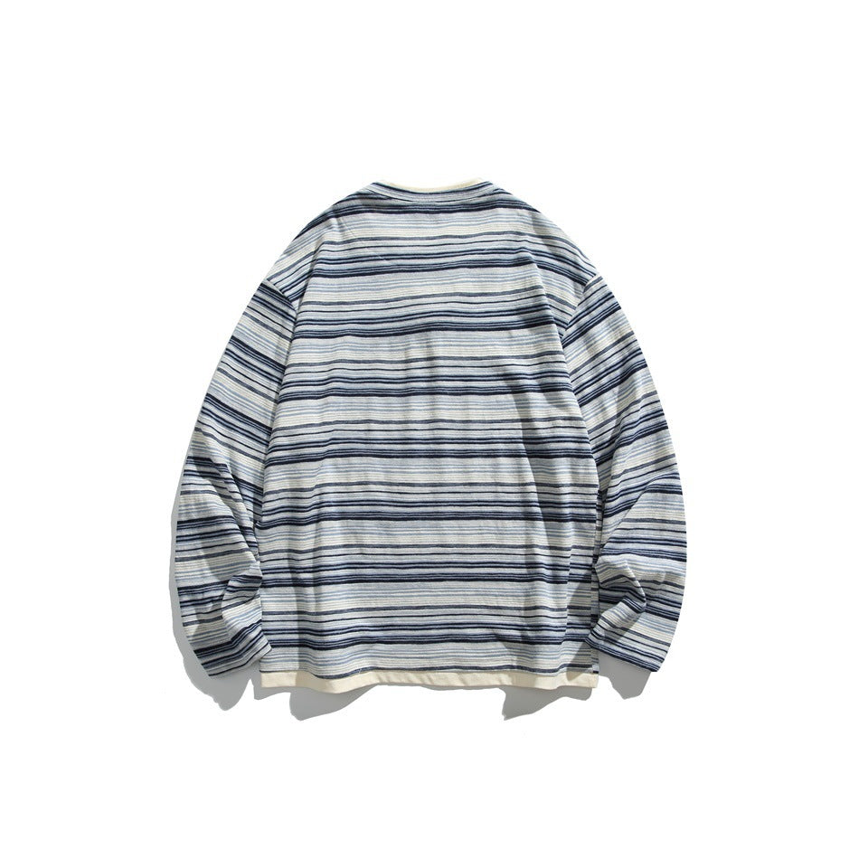 Back view of navy and light blue striped long-sleeve sweatshirt with cream hem trim, flat lay