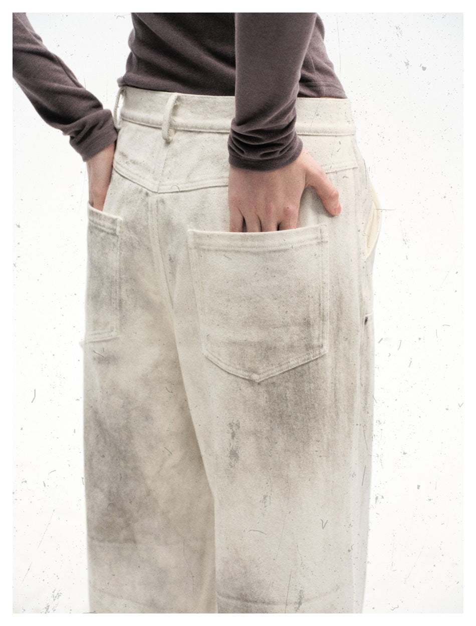 Close rear view of off-white wide-leg trousers, showing the waistband, belt loops, and large back patch pockets.