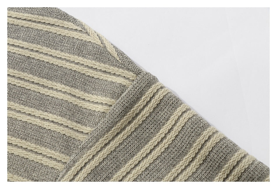 Close-up of the garment's striped knit shoulder seam in gray-beige and cream.